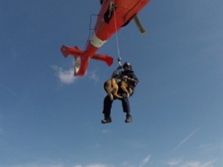 A Canine Explosive Detection Team of the U.S. Coast Guard conducts hoist training with MH-65 Dolphin helicopter and CG boat crew. (Photo PO 3rd Class Ryan Dickinson, USCG, March 29, 2018).