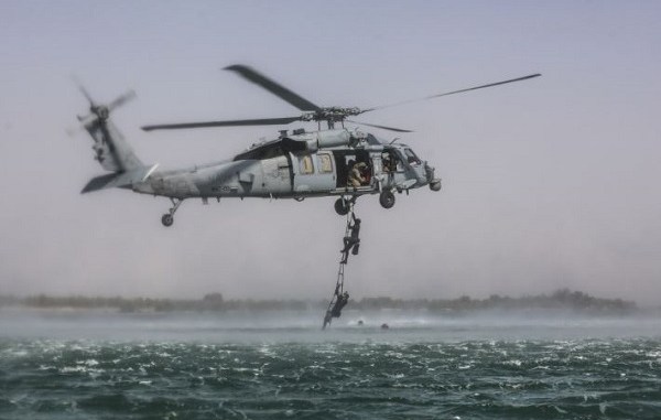 5th SFG Soldiers ascend a rope ladder while conducting maritime exfilitration.