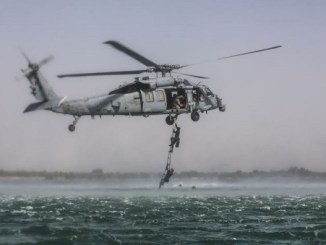 5th SFG Soldiers ascend a rope ladder while conducting maritime exfilitration.