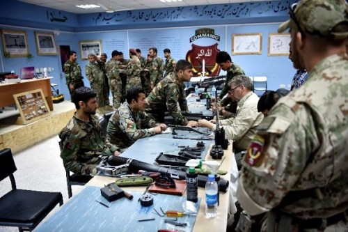 ANASOC Weapons Repairman Course Afghanistan - A Slovak SOAT member stands by to assist as Patrick Franko - a civilian contractor and trainer - provides instruction during the ANASOC Weapons Repairman Course. Photo by MSG Felix Figueroa, NSOCC-A, August 2018).